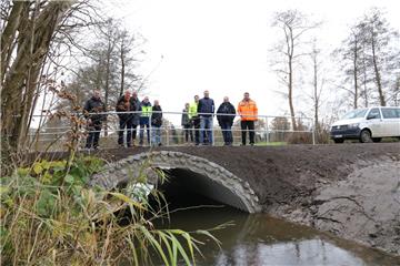 Verschaffen sich einen Eindruck von der neuen Brücke: Heines Ortsvorsteher Nils Haarje (CDU, links), Jörn Deharde (Gemeinde Hagen, Zweiter von links) sowie Vertreter des Landkreises, des Wasserverbandes sowie der am Bau beteiligten Unternehmen.