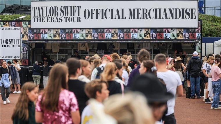 Stars wie Heilige verehren Viele Fans warten vor einem Stand mit Fanartikeln von Taylor Swift.