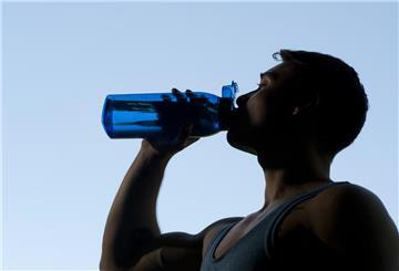 Ein Sportler trinkt aus einer Trinkflasche. Viele Hydration-Drinks enthalten unnötige Zusatzstoffe, Zucker oder Süßstoffe. Ernährungsexperten raten: Wasser, eine Prise Salz, Zitrone und etwas Honig reichen oft völlig aus.