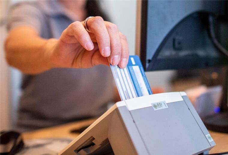  Eine Medizinische Fachangestellte schiebt in einer Hausarztpraxis die Versichertenkarte der Krankenkasse eines Patienten in das Lesegerät.  Viele Krankenkassen erhöhen 2025 erneut ihre Beiträge. Für Versicherte erhöht das den finanziellen Druck.