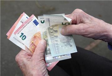 Eine ältere Frau hält eine fast leere Geldbörse in den Händen. Viele Mütter können im Alter von Altersarmut betroffen werden.