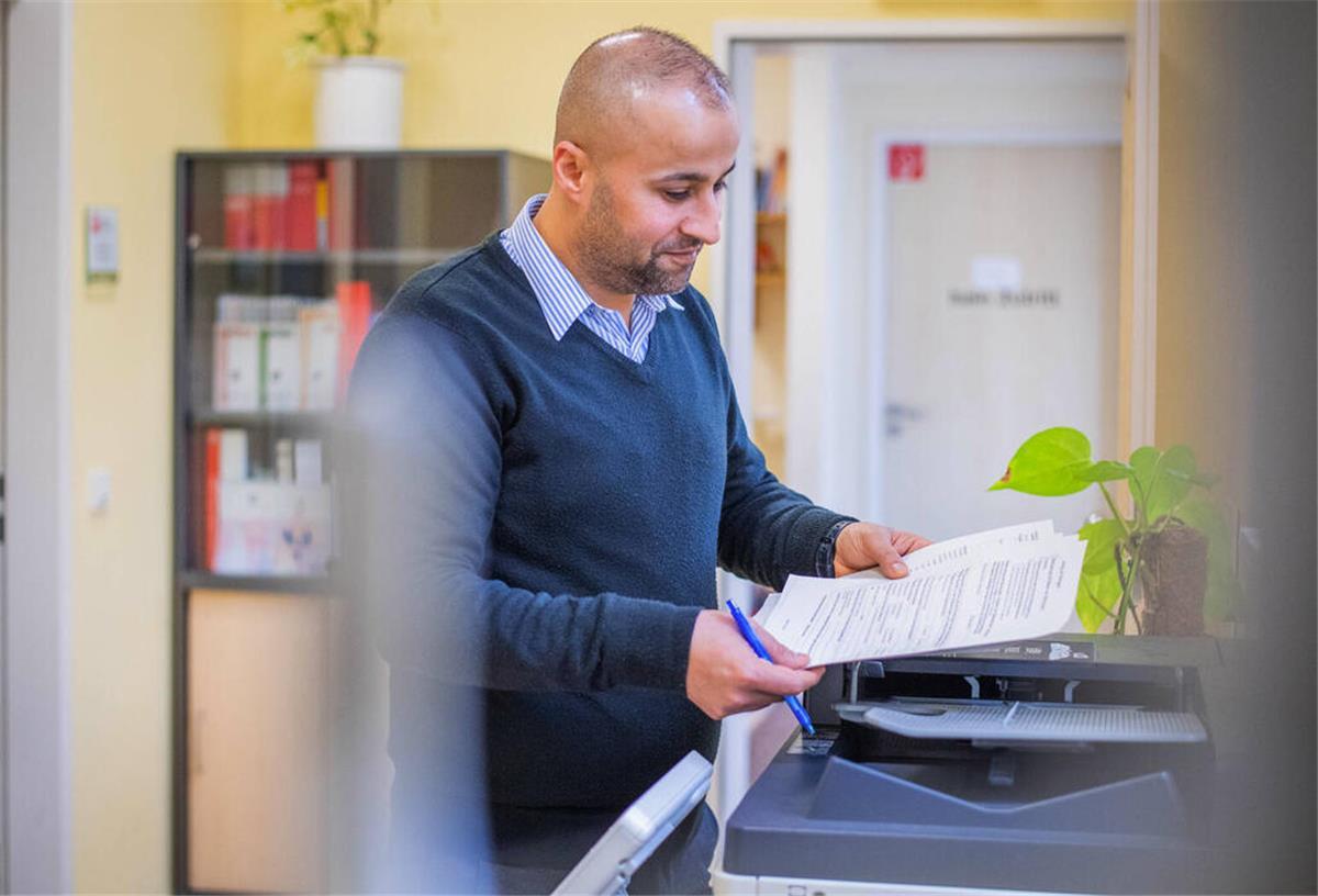 Rente zu knapp? Hier gibt‘s Extra-Geld vom Staat! Mann steht vor Drucker