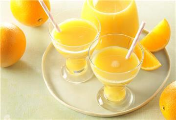 Mehrere Gläser mit Orangensaft stehen auf einem Tisch. Wir zeigen, was Vitamin C im Körper wirklich macht.