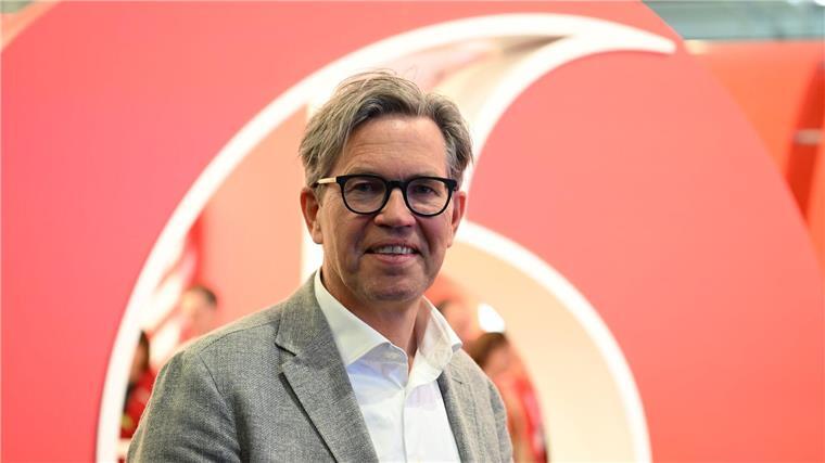 Vodafone-Deutschlandchef Marcel de Groot vor einem großen Plastik-Logo seiner Firma.