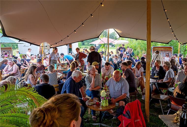 Welche Events erwarten euch im Juli im Beet und was geht beim Kneipenquiz ab? Menschen an Tischen im Grünen