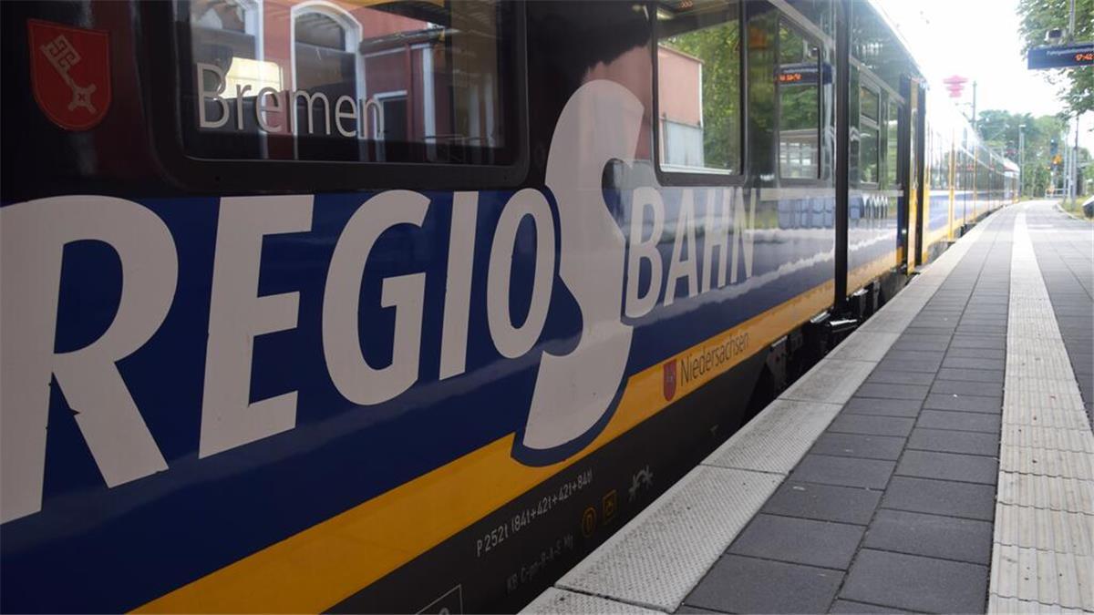 Ein Zug hält an einem Bahnhof. 