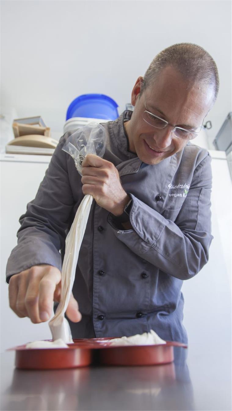 Vom Arzt zum veganen „Käsemacher“: Dr. Mudar Mannah füllt die fermentierte Cashewkern-Creme in Förmchen ein.