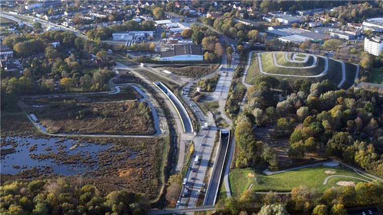 Der mächtige Hafentunnel aus der Vogelperspektive Von der Autobahn kommend steuert der Verkehr auf das östliche Tunnelportal zu. Rechts ist der Leherheider Tunnelberg gut zu erkennen.