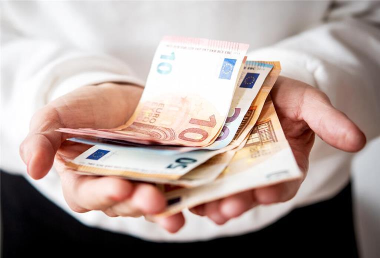 Gute Nachricht: Die Inflation geht überraschend zurück Zwei Hände halten Geldscheine