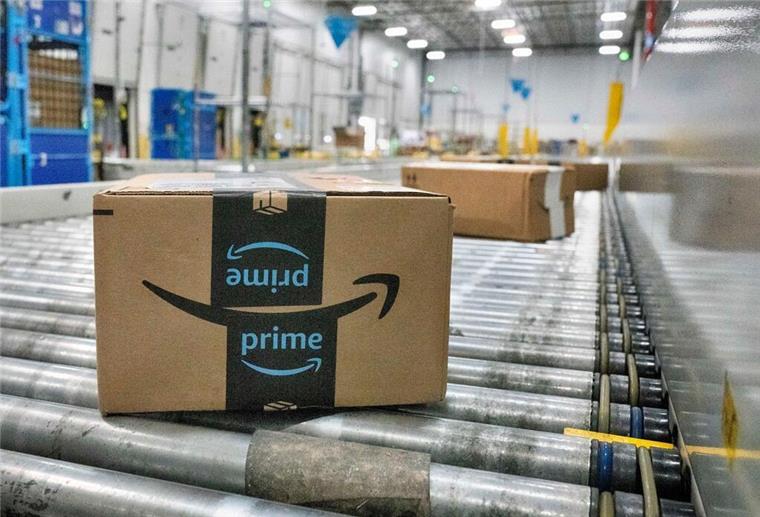 Schon vor Black Friday: Amazon kündigt nächsten Prime-Day mit satten Rabatten an Ein Amazon-Paket bewegt sich auf einem Förderband in einer Zustellstation von Amazon.