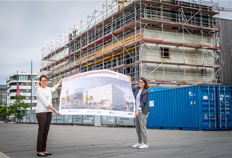 31 Fassadengesichter fürs Auswandererhaus Vor dem Erweiterungsbau des Deutschen Auswandererhauses zeigen Direktorin Dr. Simone Eick (links) und die wissenschaftliche Mitarbeiterin Lina Falivena, wie das Gebäude später aussehen soll.