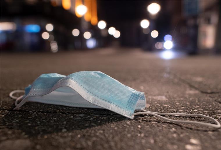 Corona-Quarantäne: Familie will Schmerzensgeld Eins Schutzmaske liegt in der Innenstadt auf dem Boden.