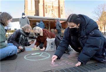 Vor der großen Kirche malen Jugendliche zahlreiche Friedensbotschaften.