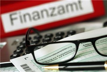 uf einem Vordruck für die Steuererklärung liegen Stift und eine Brille. 