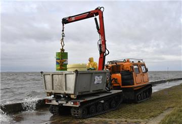 Vorsichtig wird das geborgene Fass auf den Anhänger des NLWKN gesetzt. Foto: Uli...