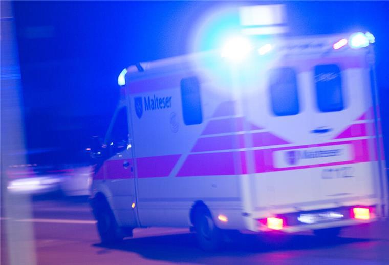 Ein Rettungswagen der Malteser fährt mit Blaulicht durch die Nacht.