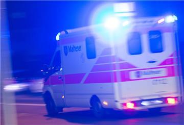 Ein Rettungswagen der Malteser fährt mit Blaulicht durch die Nacht.