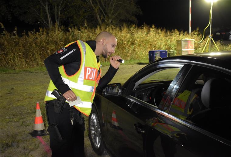 Hunderte Fahrzeuge werden am Wesertunnel kontrolliert Großkontrolle am Wesertunnel: Einsatzleiter Marius Masia blickt mit der Taschenlampe ins Innere eines Fahrzeugs.