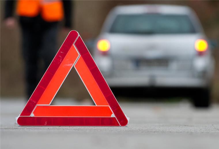 Ein Warndreieck steht auf einer Straße. Im Hintergrund ist ein Auto zu sehen. Ab 2026 darf das Warndreieck in Spanien nicht mehr genutzt werden, denn es gibt eine Alternative.