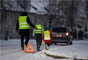 Schnee auf Straße Menschen tragen Warnwesten