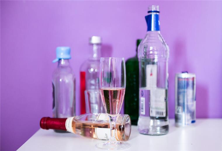 Experte erklärt: Deshalb vertragen manche mehr Alkohol als andere Flaschen mit Alkohol sowie Gläser stehen auf einem Nachttisch.