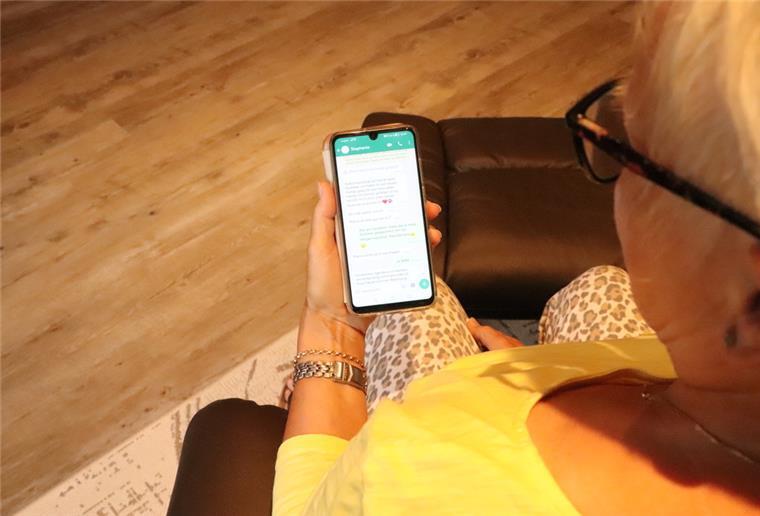 Eine Frau schaut auf ihr Handy und liest eine Nachricht.