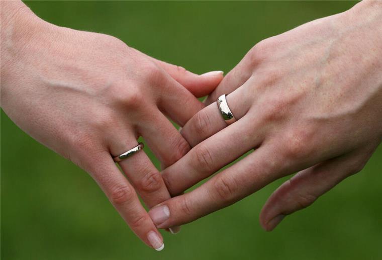  Ein frisch getrautes Brautpaar hält sich die Hände.  Was sich an den Händen verbindet, darf sich jetzt auch im Namen zeigen – das neue Namensrecht schafft ein sprachliches Pendant zur symbolischen Geste.