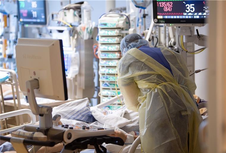 Ein Krankenpfleger versorgt einen Menschen auf der Intensivstation.