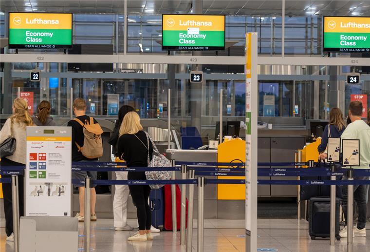 Nach Pilotenstreik: So läuft der Flugbetrieb bei Lufthansa Passagiere stehen an einem Check-in-Schalter der Lufthansa.