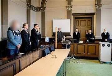 Ein wegen zweifachen Mordes und versuchten Mordes angeklagter Mann steht kurz vor Prozessfortsetzung in einem Gerichtssaal im Landgericht Verden neben seinen Verteidigern Jan Raschka (2.v.l.) und Jakob Struif.