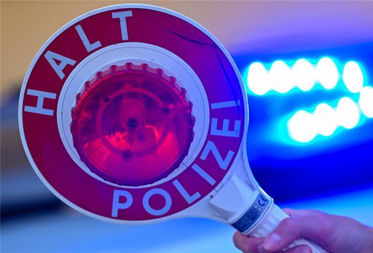 Weiterfahrt untersagt: Polizei stoppt Lkw-Fahrer Ein Polizist hält eine Polizeikelle in der Hand.