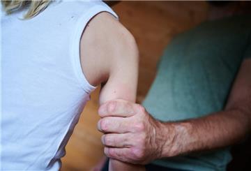 Ein Mann hält ein Kind fest am Arm (gestellte Szene)