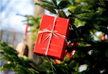 Ein Geschenk hängt an einem Weihnachtsbaum