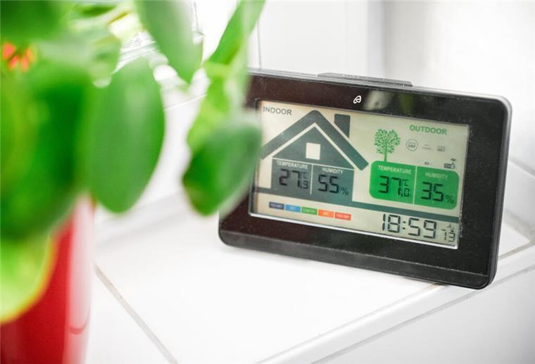 Sommerhitze im Dachgeschoss: Diese Maßnahmen kühlen die Wohnung um 5 Grad Eine Wetterstation auf der Fensterbank zeigt hohe Temperaturen in der Wohnung und draußen an