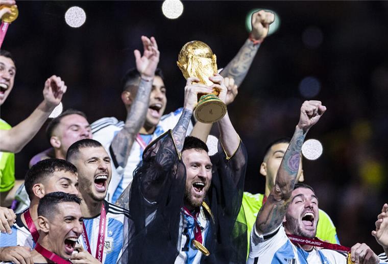  Argentiniens Lionel Messi jubelt mit WM-Pokal und seiner Mannschaft. 