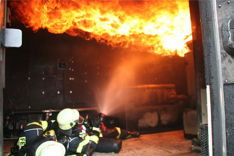 Feuerwehren aus Loxstedt, Hagen und Beverstedt üben im Heißcontainer Wenn ein Brandherd den ganzen Raum erfasst: Andreas Timmler und Björn Drewes bekämpfen den so genannten Flashover im Übungscontainer vorschriftsmäßig, indem sie in liegender Position das Feuer über sich unter Kontrolle bringen.