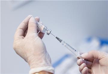 Eine Spritze wird mit Covid-19-Impfstoff aufgezogen