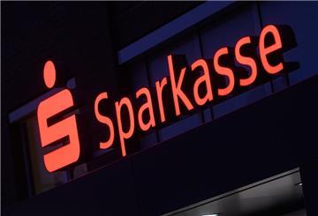 Ein Schriftzug der Sparkasse leuchtet an einer Filiale. Aktuell sind Sparkassen-Kunden im Visier von Betrügern. 