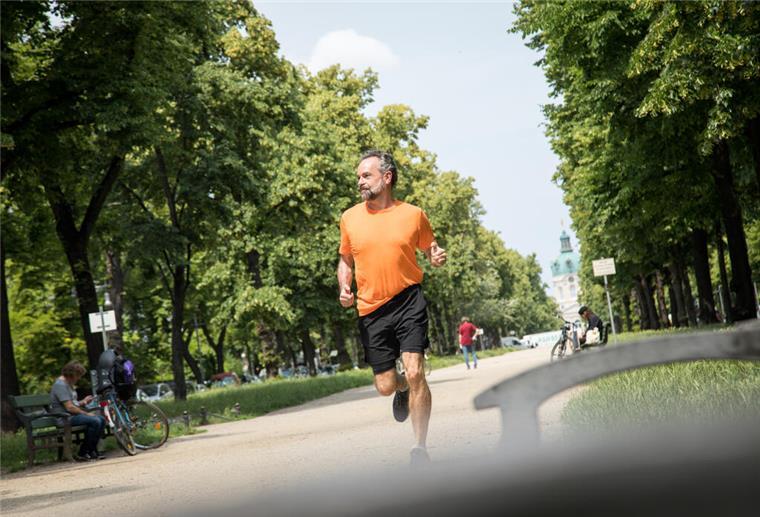  Ein Mann joggt durch einen Park.