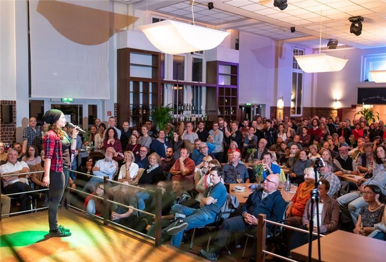 Große Bühne für die Wissenschaft im Bremerhavener „Apollo“ Eine Frau steht auf einer Bühne. Vor ihr sind zahlreiche Menschen im Publikum.