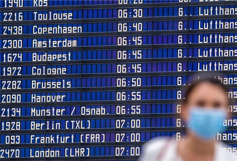 Corona: Wohin in den Herbstferien reisen? Eine Frau steht vor einer Anzeigetafel im Flughafen.