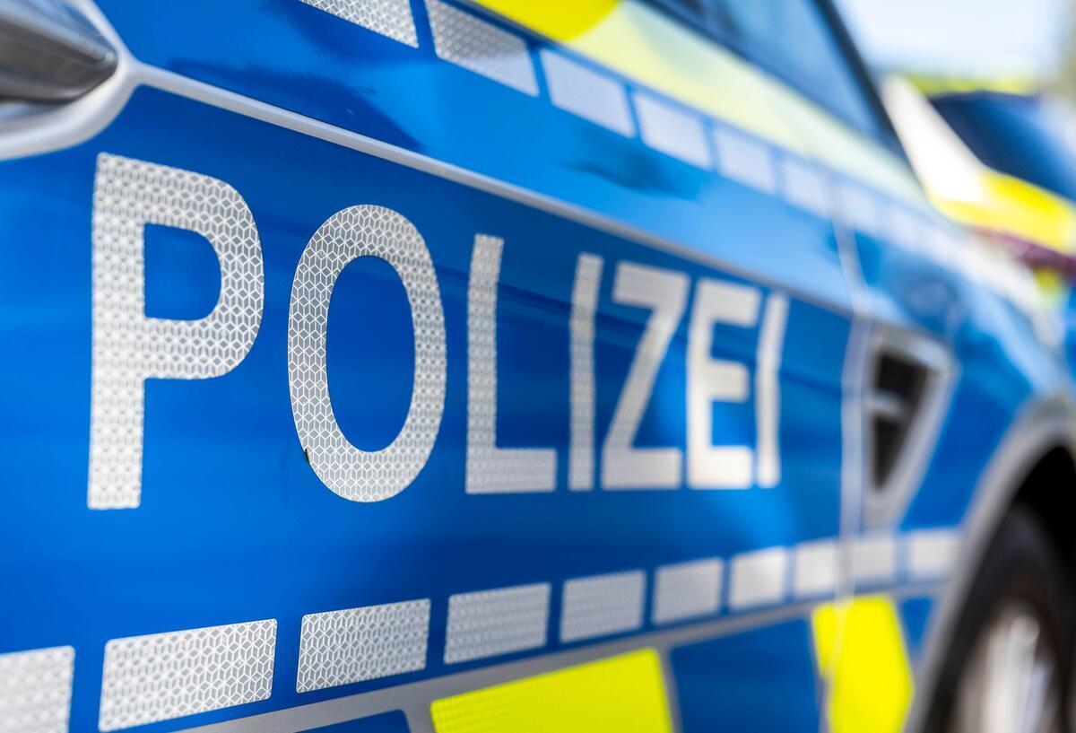 An der Tür von einem Streifenwagen steht der Schriftzug „Polizei“.