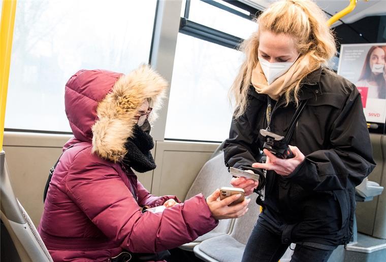 Eine Prüfdienst-Mitarbeiterin der Verkehrsbetriebe Hamburg-Holstein (VHH) kontrolliert in einem Bus den 3-G-Nachweis einer Passagierin.