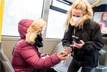 Eine Prüfdienst-Mitarbeiterin der Verkehrsbetriebe Hamburg-Holstein (VHH) kontrolliert in einem Bus den 3-G-Nachweis einer Passagierin.