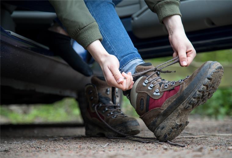 Autoclub warnt: Mit Wanderstiefeln nicht ans Steuer setzen Autofahrer zieht Wanderschuhe an