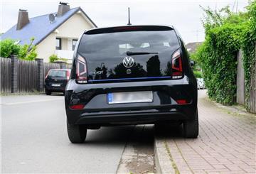  Ein Auto parkt teilweise auf einem Gehweg. 