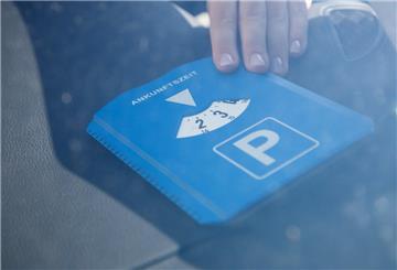 In einem Auto liegt eine blau-weiße Parscheibe.