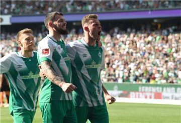 Werders Oliver Burke (M) jubelt in der Nachspielzeit, mit Marvin Ducksch (r) und Mitchell Weiser über sein Tor zum 2:2.
