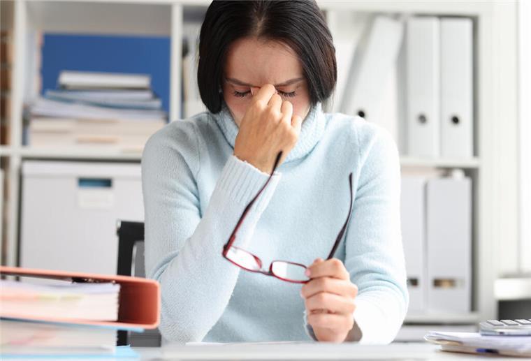 Wenn der Wetterumschwung zu schaffe macht Frau mit Kopfschmerzen