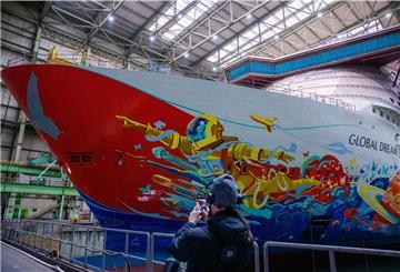Ein Tontechniker filmt mit seinem Handy den Astronauten auf der Bugspitze des im Bau befindlichen Kreuzfahrtschiff «Global Dream» in der Schiffbauhalle.